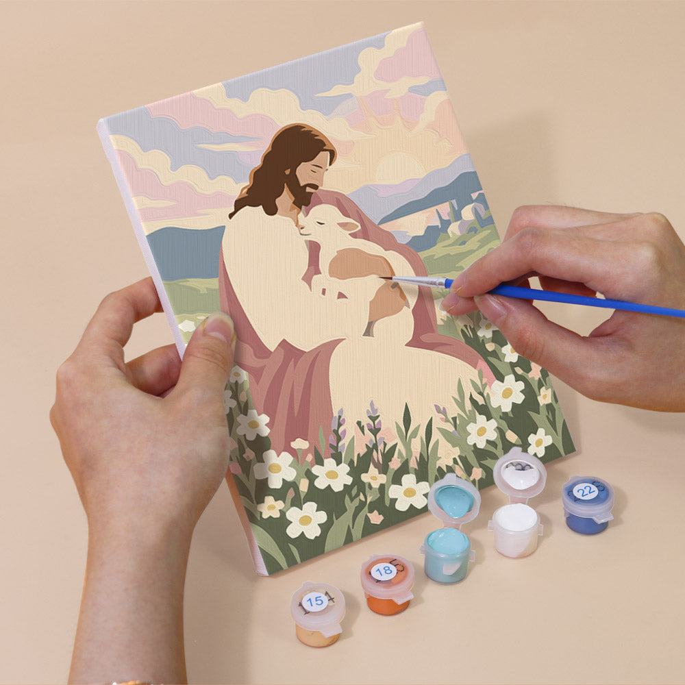 Hand holding a Faith & Grace mini canvas while painting the details