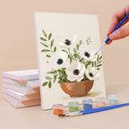 Painting a Farmhouse Posies mini canvas propped up beside numbered acrylic paints