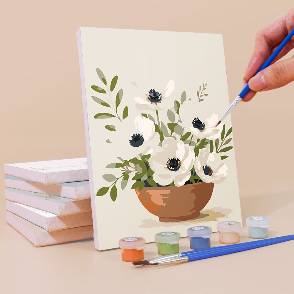 Painting a Farmhouse Posies mini canvas propped up beside numbered acrylic paints