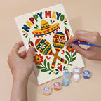 Hand holding a Fiesta Time mini canvas while painting the details
