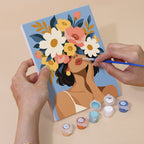 Hand holding a Flower Crowned mini canvas while painting the details