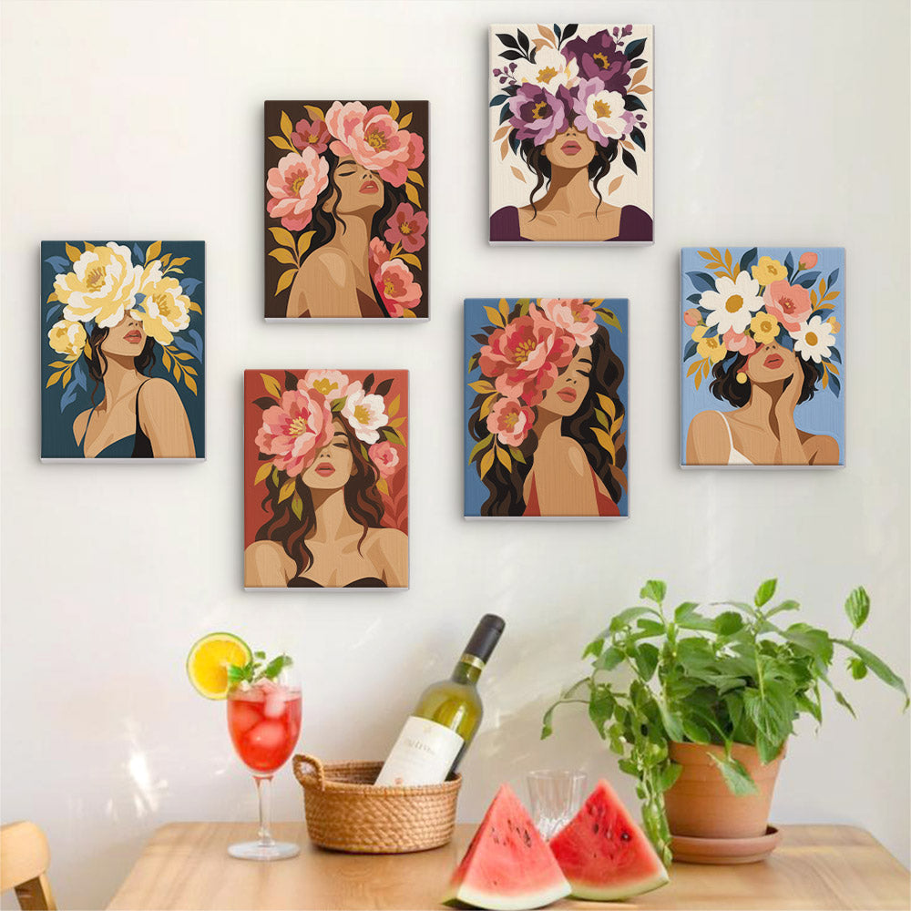 Six finished Flower Crowned mini paintings hung on a wall above a table
