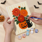 Hand holding a Folk Art Halloween mini canvas while painting the details