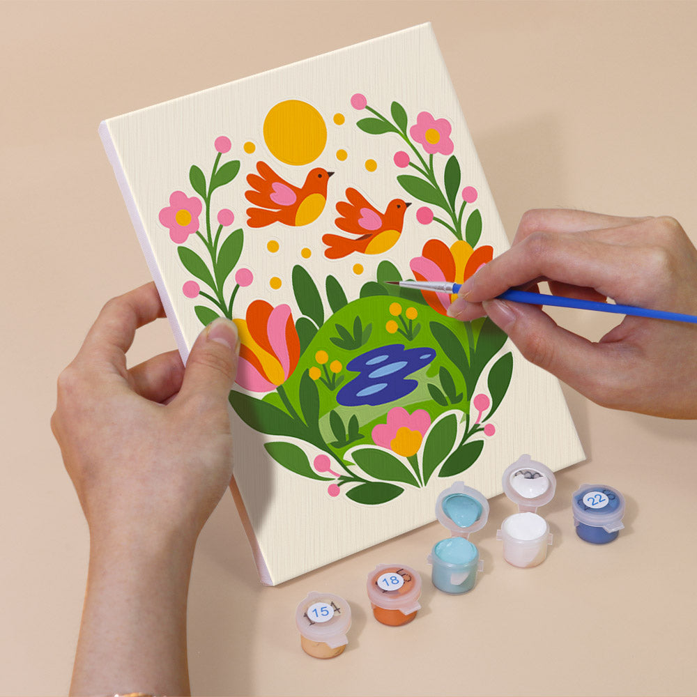 Hand holding a Folk Blossoms mini canvas while painting the details