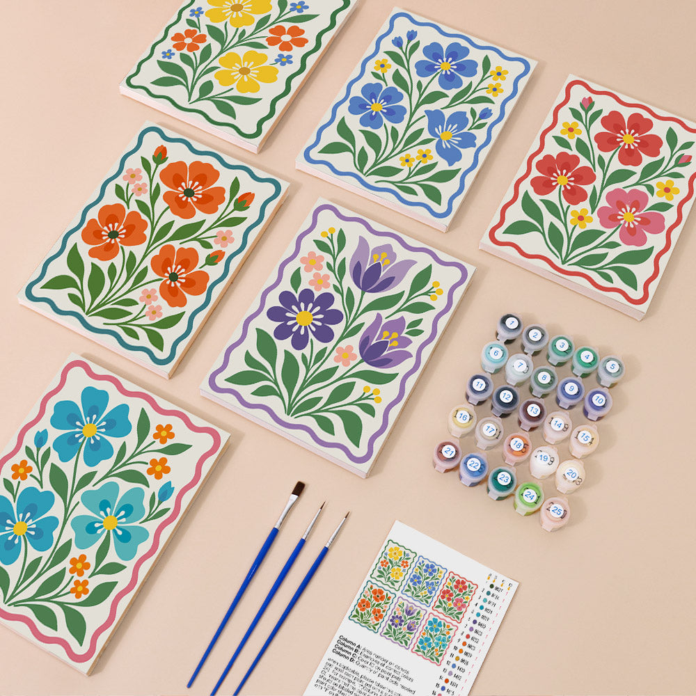 Folk Flower Tiles mini paint by numbers set: six folk-art flower canvases with wavy borders laid out with numbered paint pots, three brushes and the reference layout