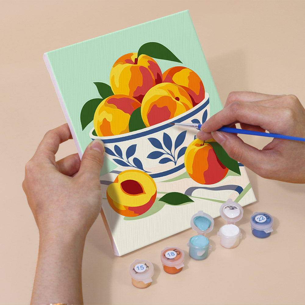 Hand holding a Fresh Fruit Bowls mini canvas while painting the details