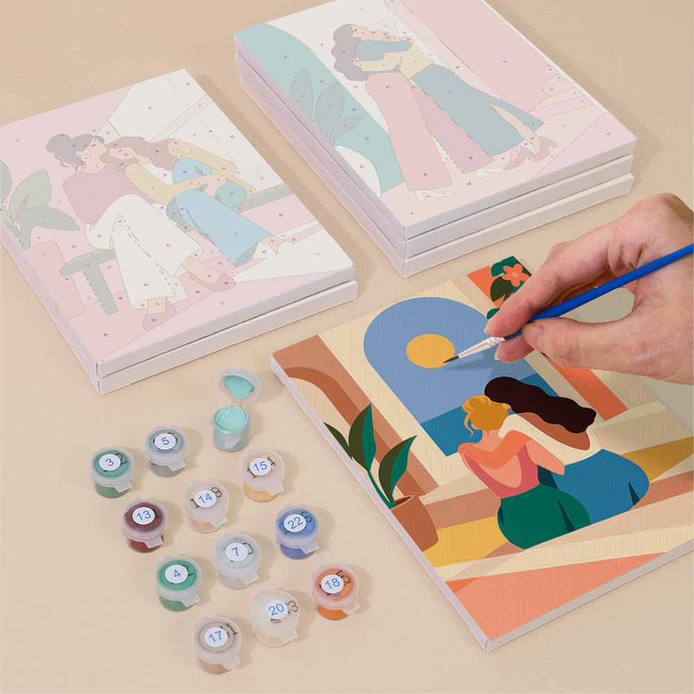 Painting one of the Friendship Hugs designs next to a stack of mini canvases