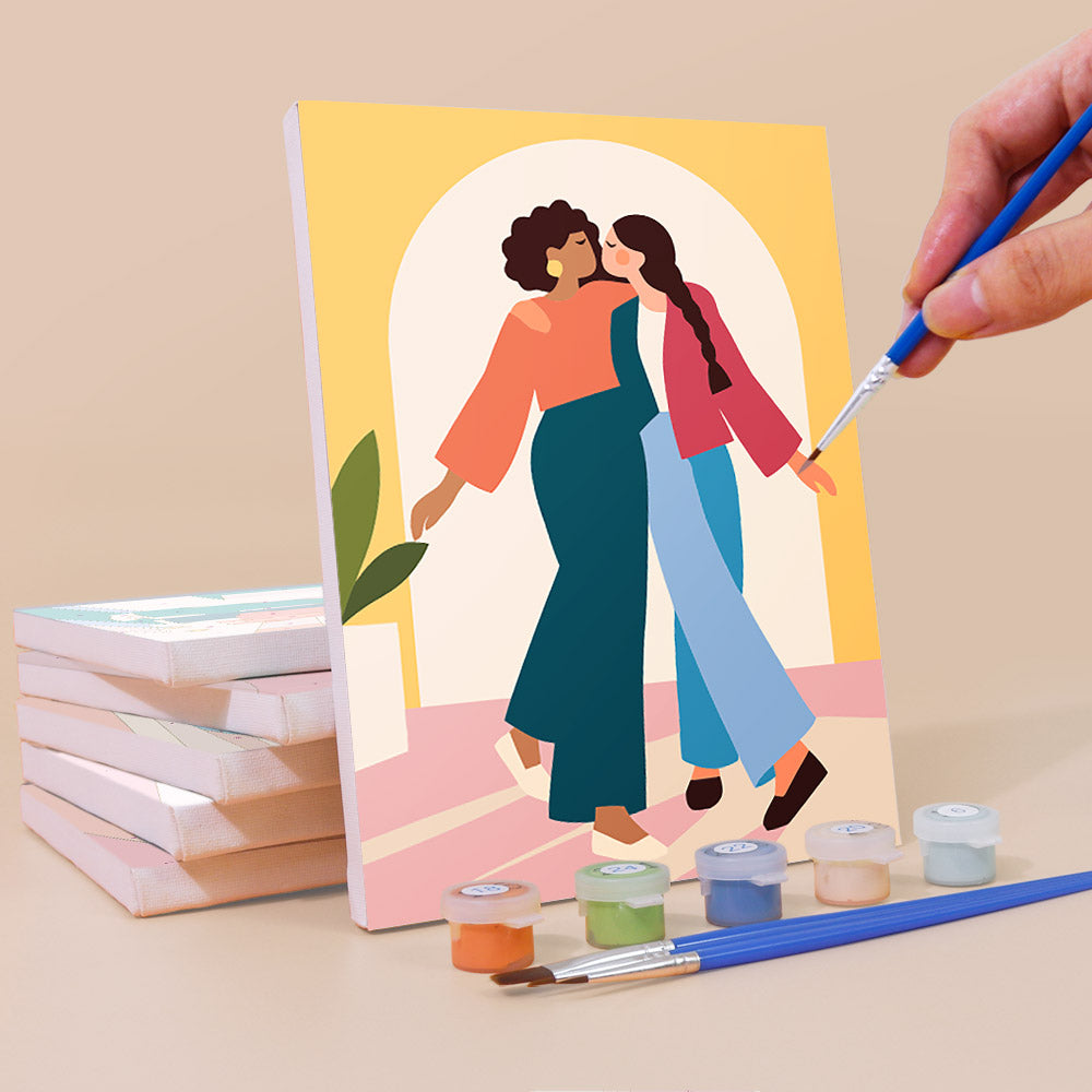 Painting a Friendship Hugs mini canvas propped up beside numbered acrylic paints