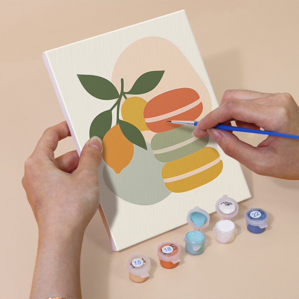 Hand holding a Fruit Branches mini canvas while painting the details