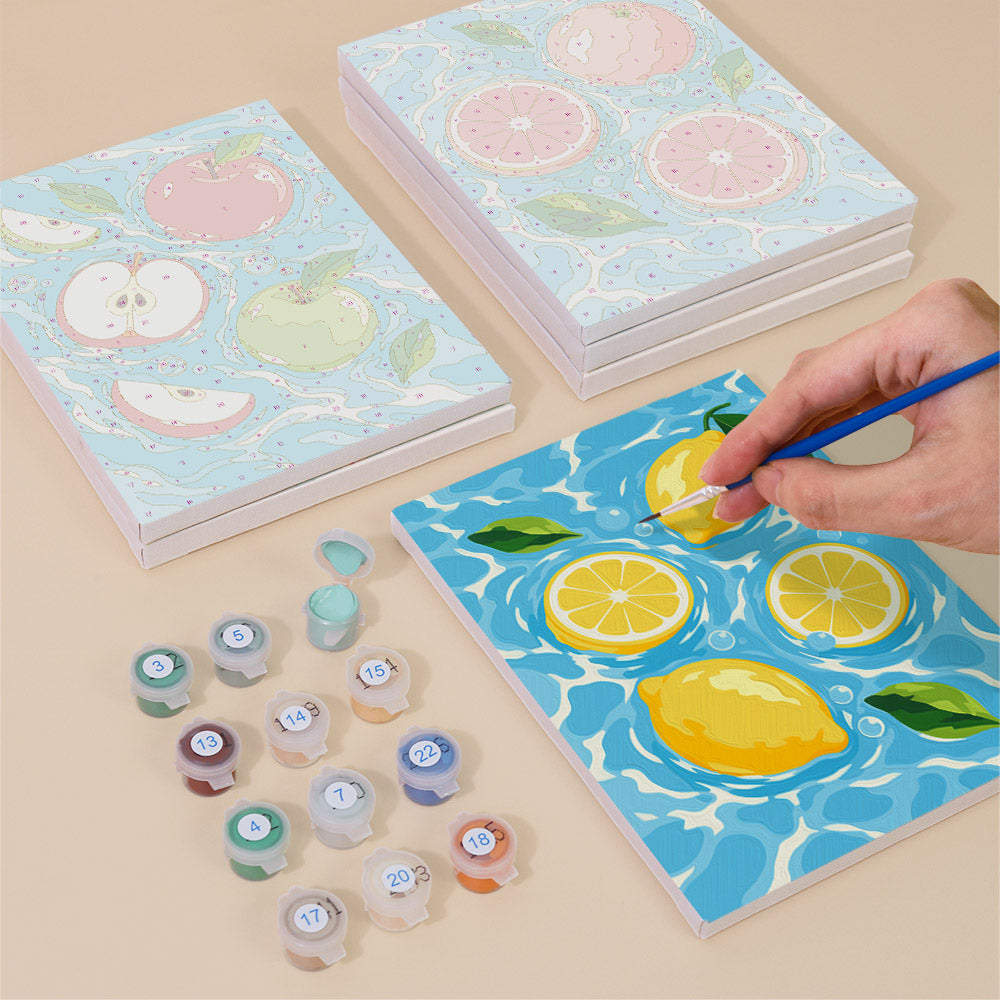 Painting one of the Fruit Splash designs next to a stack of mini canvases