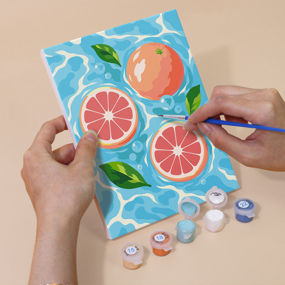 Hand holding a Fruit Splash mini canvas while painting the details