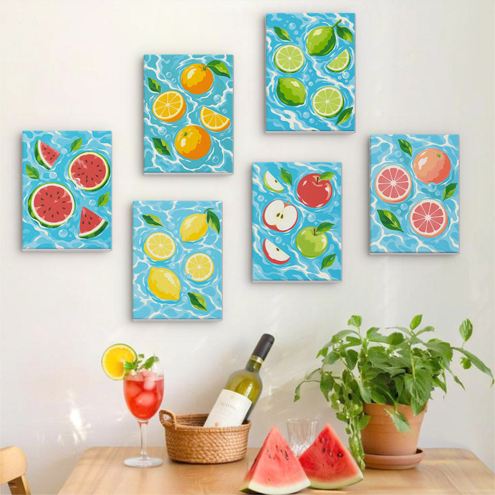 Six finished Fruit Splash mini paintings hung on a wall above a table