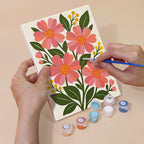 Hand holding a Garden Bouquets mini canvas while painting the details