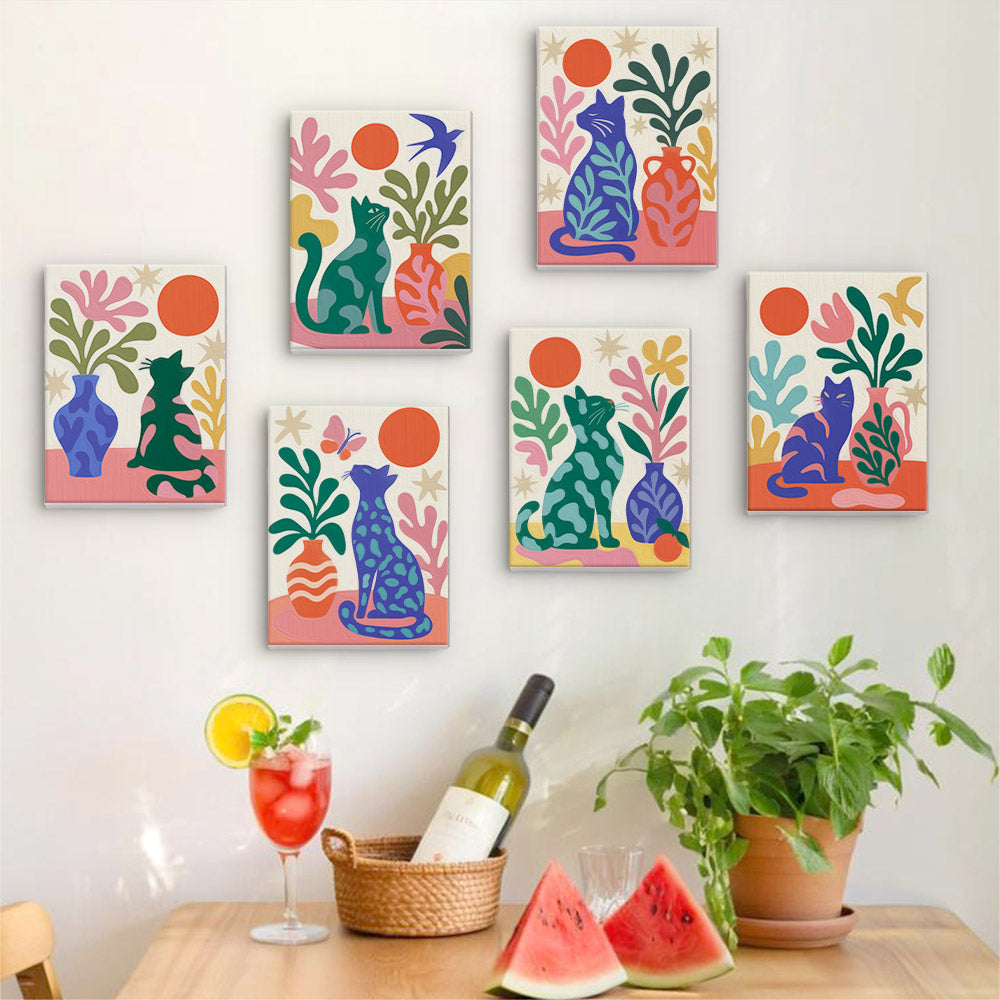 Six finished Garden Cats mini paintings hung on a wall above a table