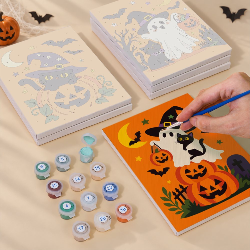 Painting one of the Ghosts in Witch Hats designs next to a stack of mini canvases
