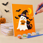 Painting a Ghosts in Witch Hats mini canvas propped up beside numbered acrylic paints