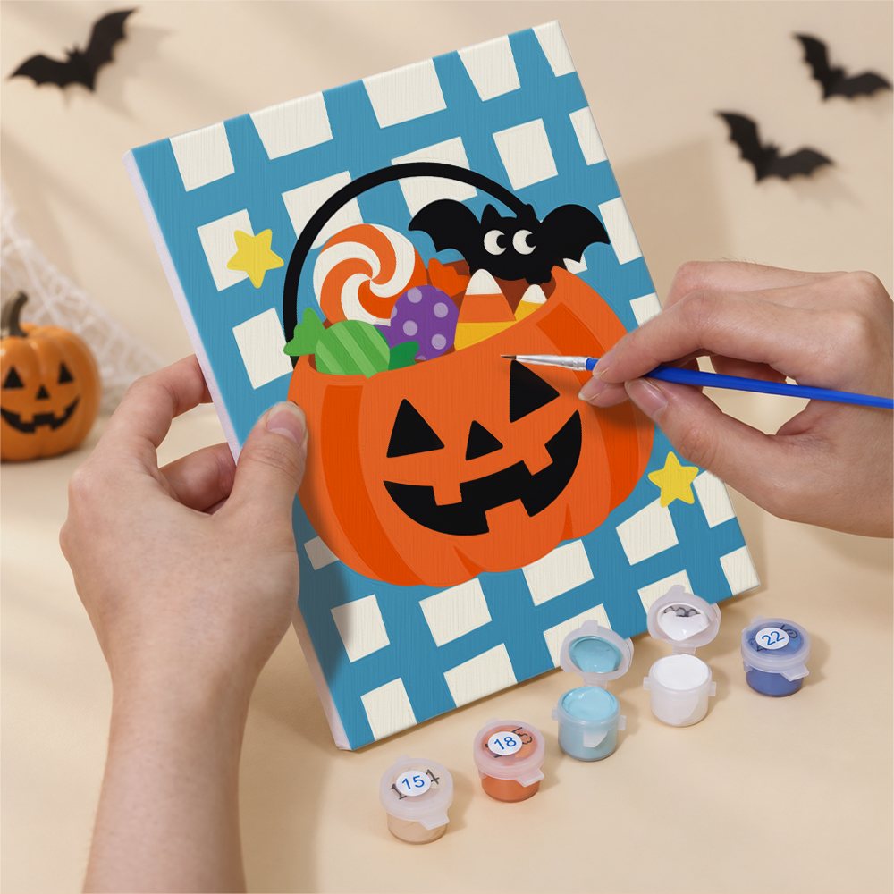 Hand holding a Gingham Halloween mini canvas while painting the details
