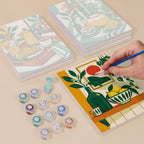 Painting one of the Golden Hour Tables designs next to a stack of mini canvases