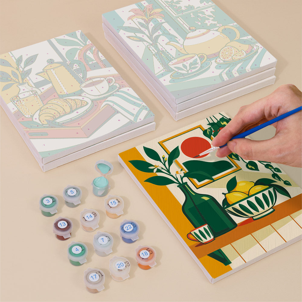 Painting one of the Golden Hour Tables designs next to a stack of mini canvases