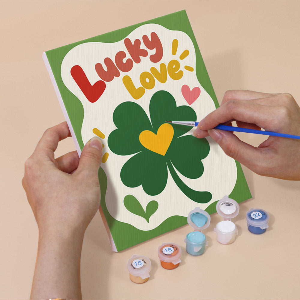 Hand holding a Good Mood Club mini canvas while painting the details