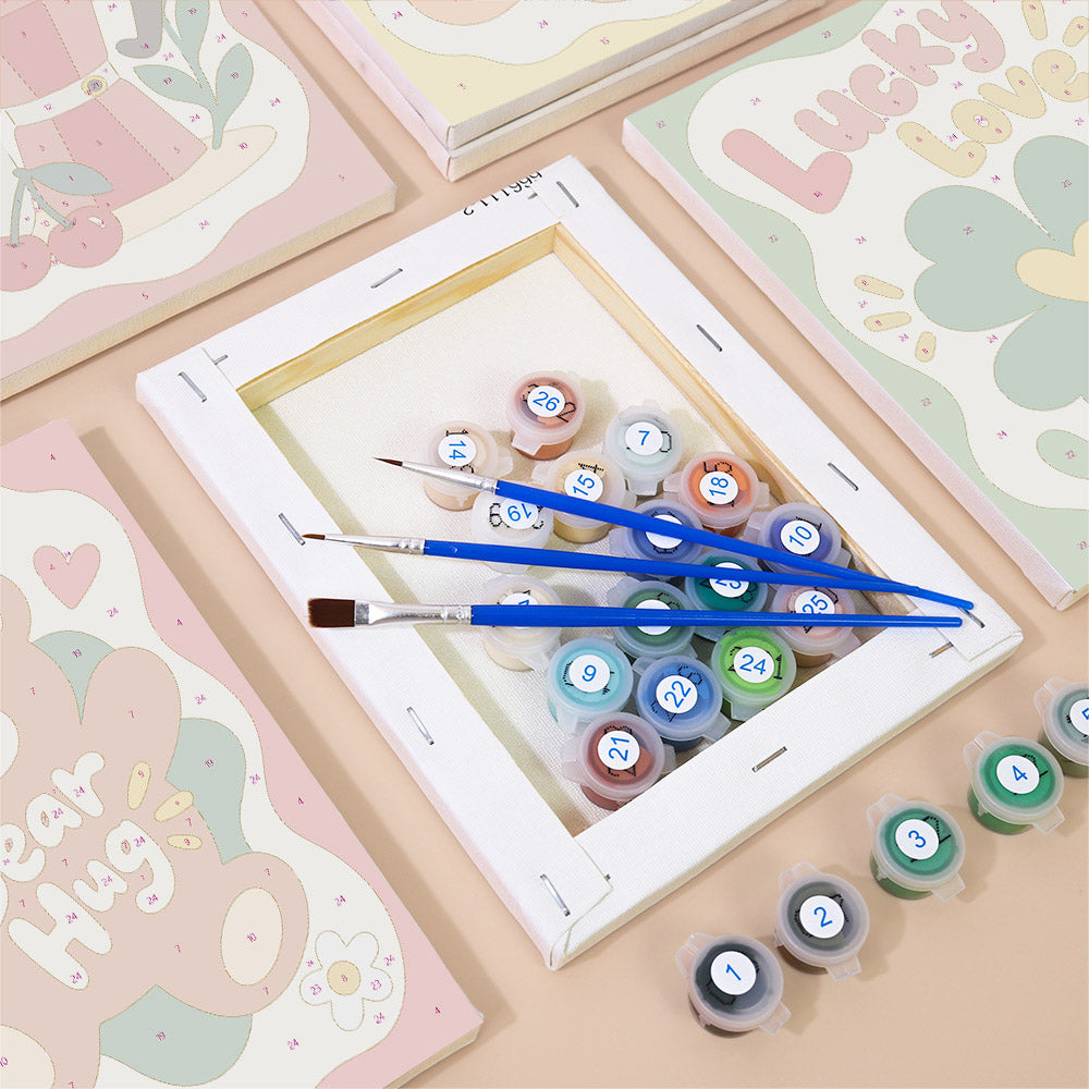 Numbered paint pots and brushes on a pre-stretched Good Mood Club mini canvas