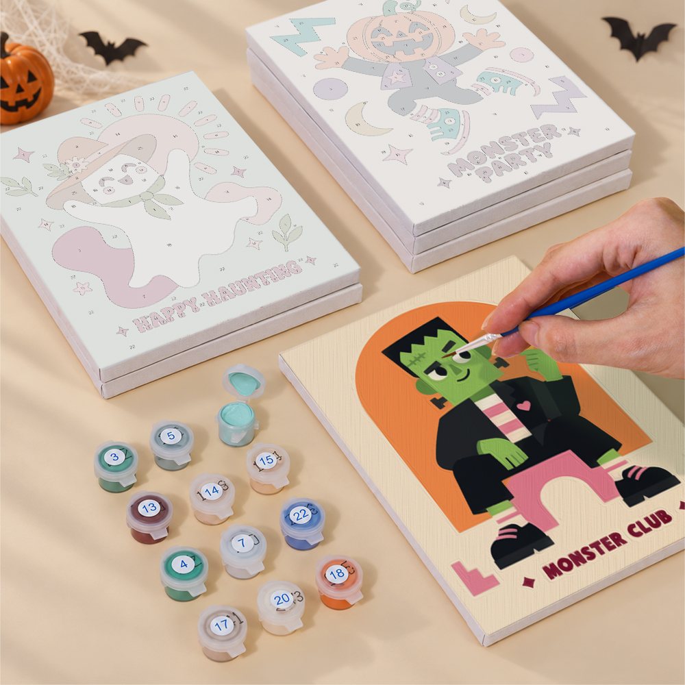 Painting one of the Groovy Monster Club designs next to a stack of mini canvases