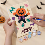Hand holding a Groovy Monster Club mini canvas while painting the details