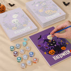 Painting one of the Halloween Banner Friends designs next to a stack of mini canvases