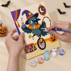 Hand holding a Halloween Circus Critters mini canvas while painting the details