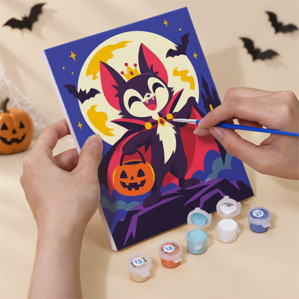 Hand holding a Halloween Costume Carnival mini canvas while painting the details
