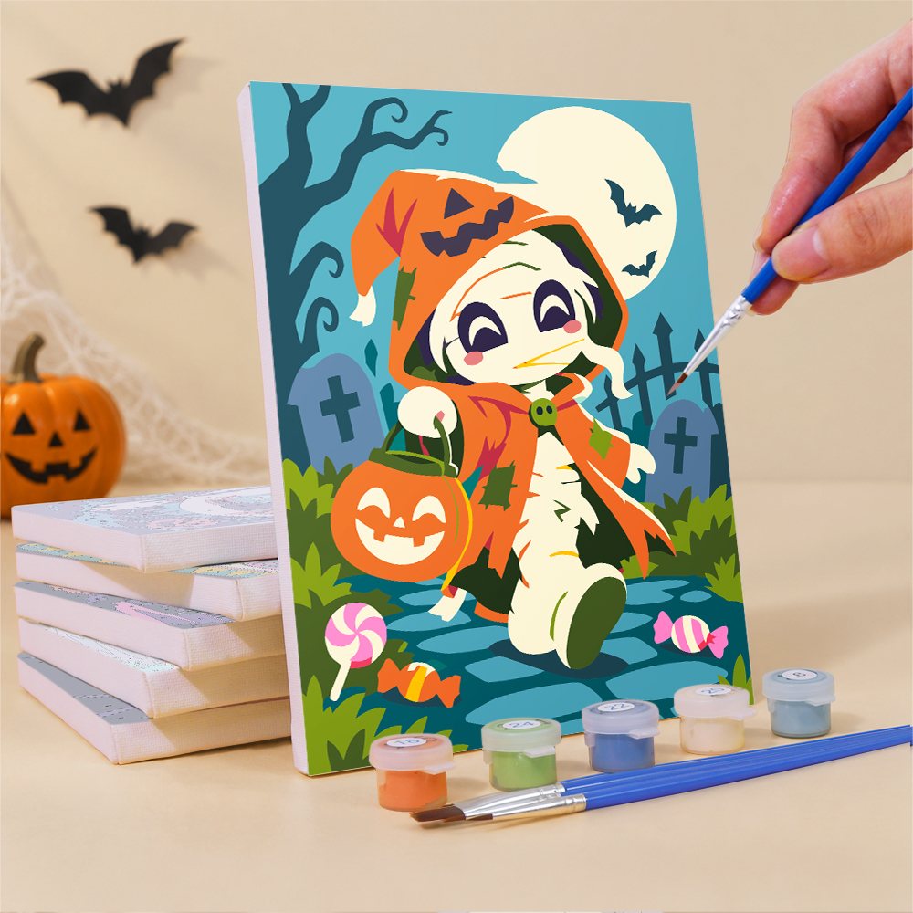 Painting a Halloween Costume Carnival mini canvas propped up beside numbered acrylic paints