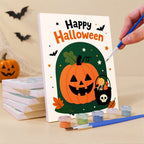 Painting a Halloween Greetings mini canvas propped up beside numbered acrylic paints