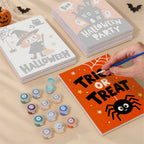 Painting one of the Halloween Party Signs designs next to a stack of mini canvases