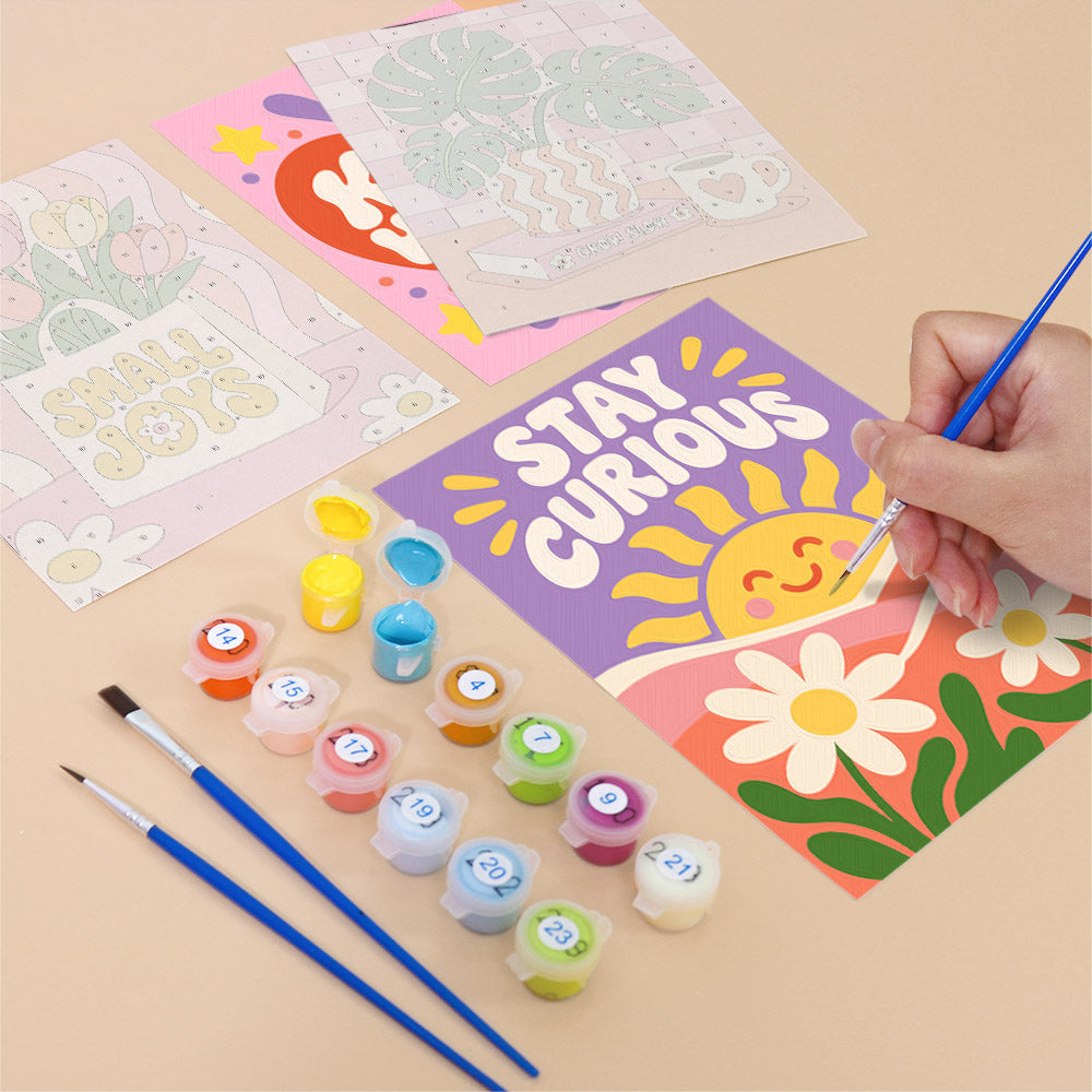 Filling in a Happy Words mini canvas with numbered acrylic paints and a fine brush