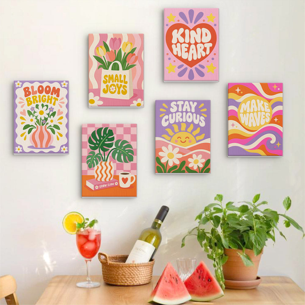 Six finished Happy Words mini paintings hung on a wall above a table