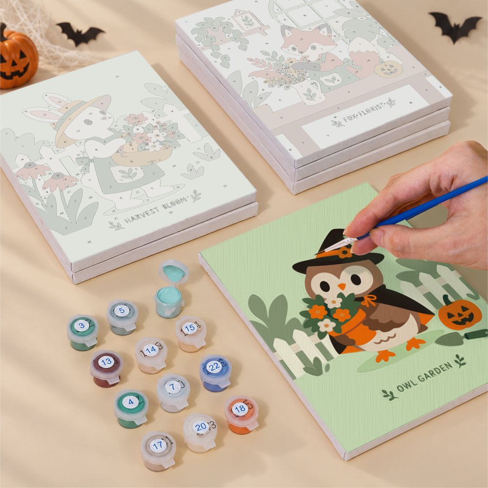 Painting one of the Harvest Garden Friends designs next to a stack of mini canvases