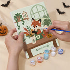 Hand holding a Harvest Garden Friends mini canvas while painting the details