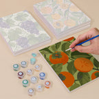 Painting one of the Harvest Patterns designs next to a stack of mini canvases