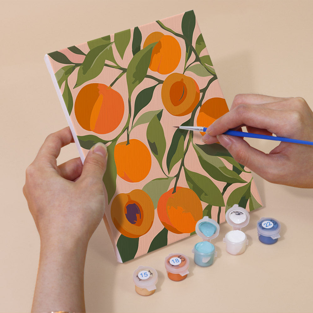 Hand holding a Harvest Patterns mini canvas while painting the details