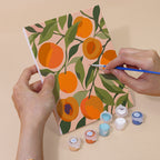 Hand holding a Harvest Patterns mini canvas while painting the details