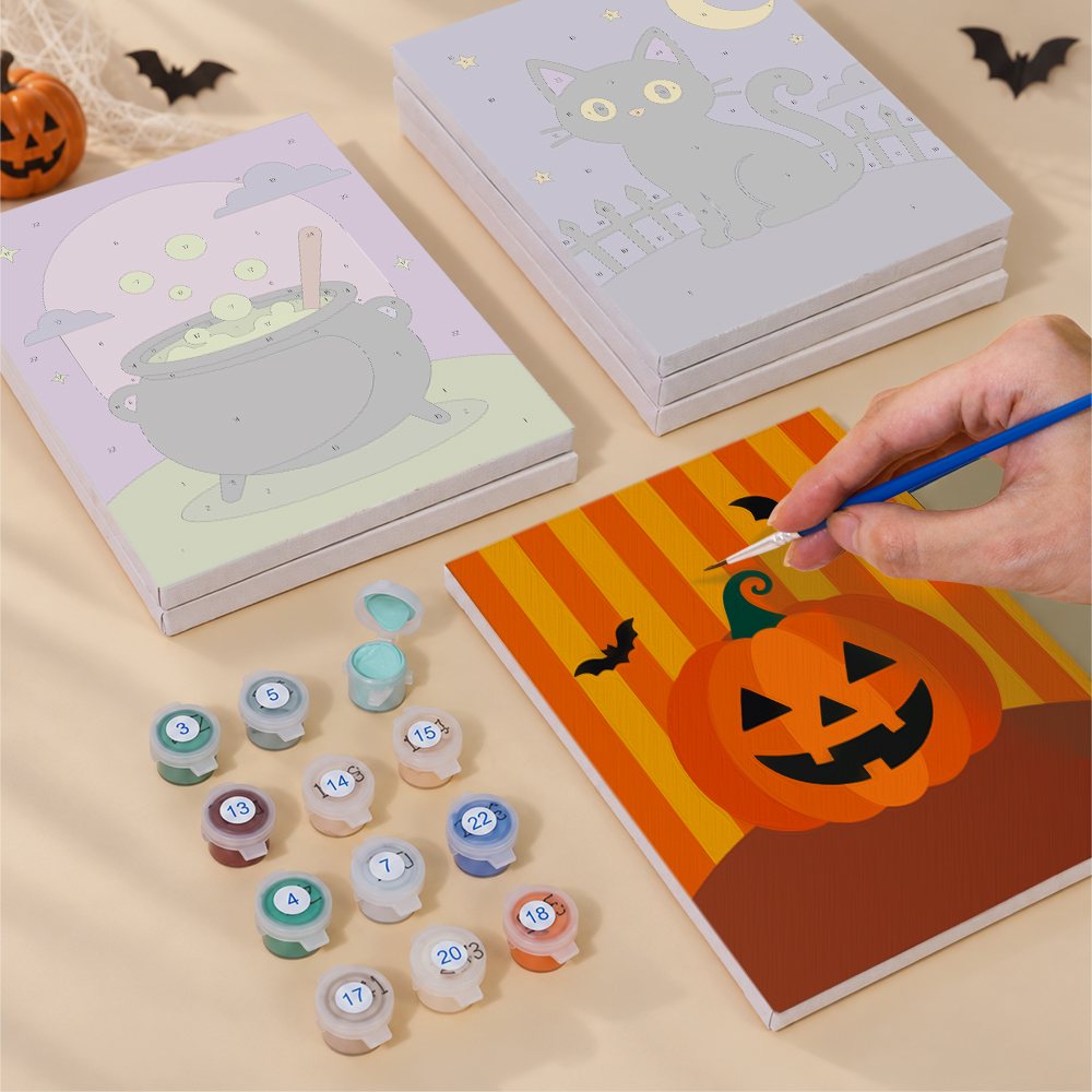 Painting one of the Haunted Night Icons designs next to a stack of mini canvases