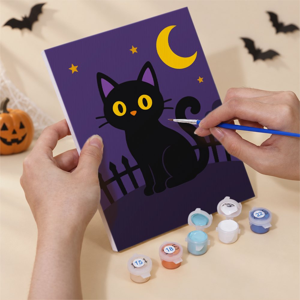 Hand holding a Haunted Night Icons mini canvas while painting the details