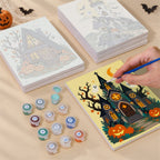 Painting one of the Haunted Pumpkin Cottages designs next to a stack of mini canvases