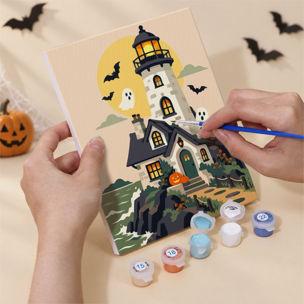 Hand holding a Haunted Pumpkin Cottages mini canvas while painting the details