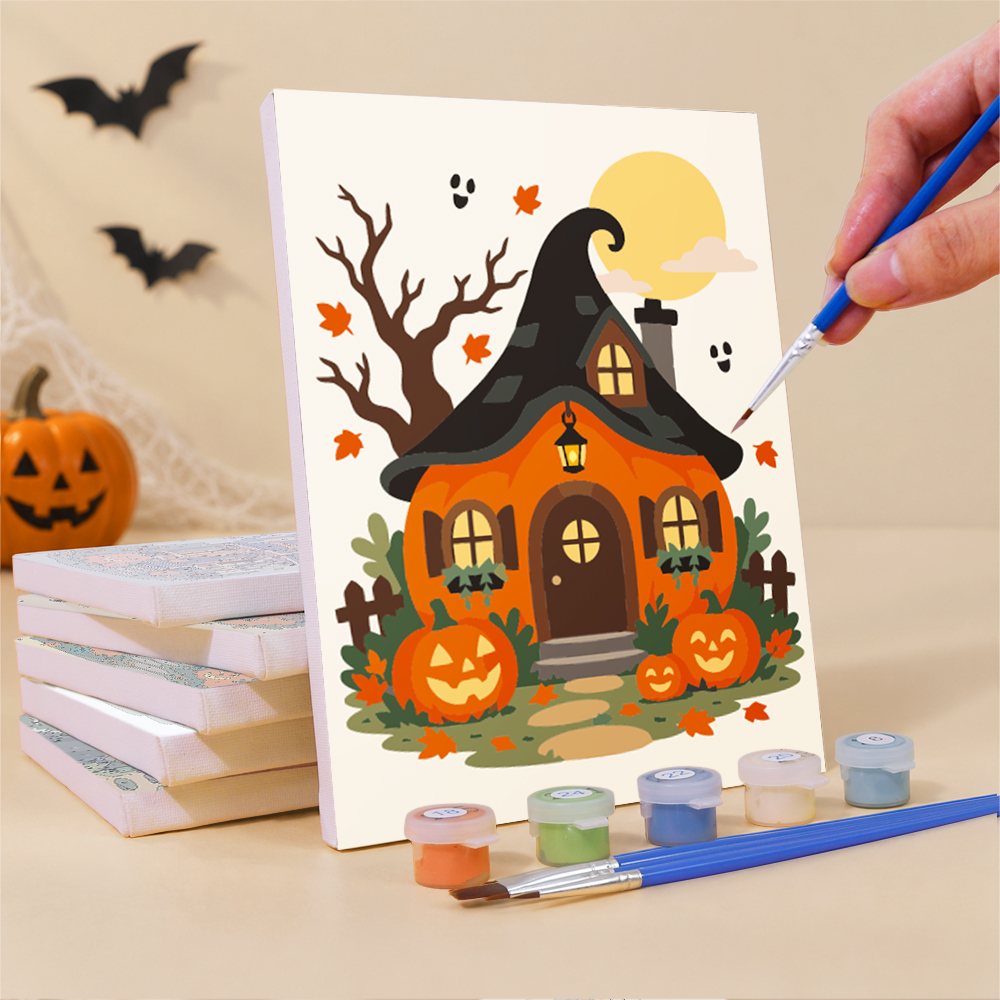 Painting a Haunted Pumpkin Cottages mini canvas propped up beside numbered acrylic paints