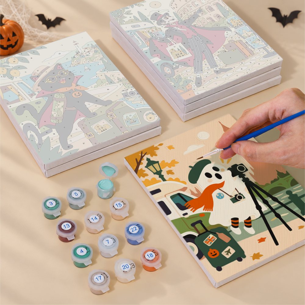 Painting one of the Haunted World Travelers designs next to a stack of mini canvases