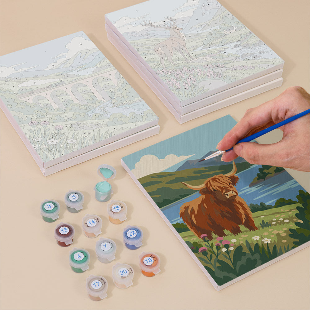 Painting one of the Highland Journey designs next to a stack of mini canvases
