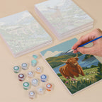 Painting one of the Highland Journey designs next to a stack of mini canvases
