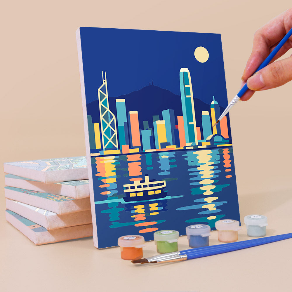 Painting a Hong Kong Harbor mini canvas propped up beside numbered acrylic paints