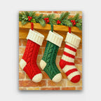 Hung by the Mantel paint by numbers kit of three knitted Christmas stockings hanging from a wooden mantel with a pine garland